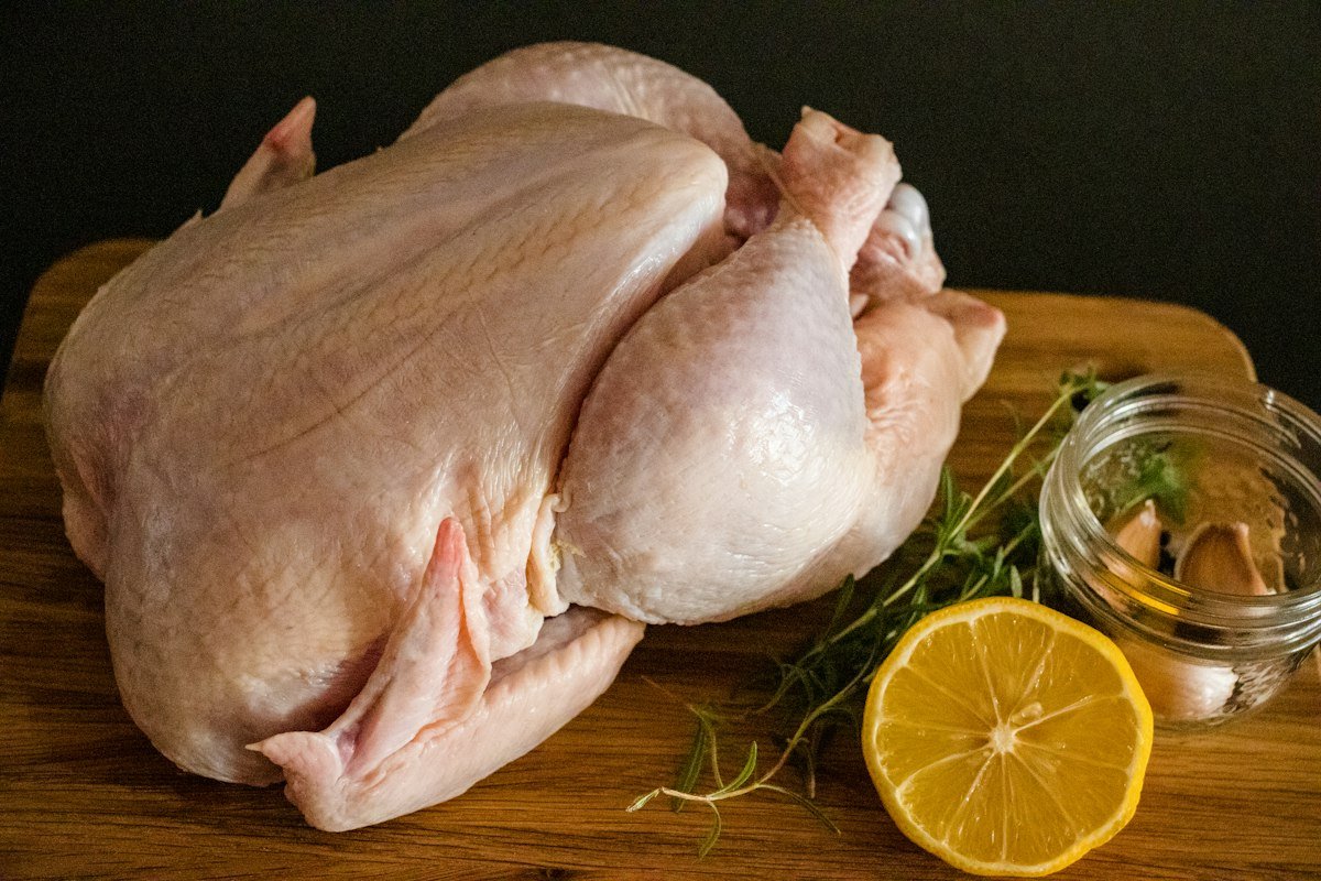 Fresh whole chicken on a wooden board